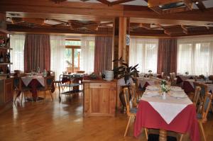 a dining room with tables and chairs and windows at Hotel Tourist in Valtournenche