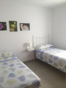 two beds in a room with pictures on the wall at Ses Sivines 25 in Ciutadella +32 photos