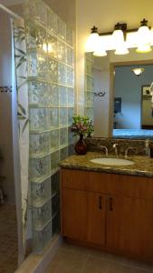 y baño con lavabo y espejo. en Kuuipo Cottage, en Mountain View
