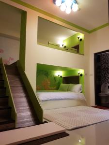 a bedroom with a bed with a green accent wall at Childlike Innocence Homestay in Ji'an