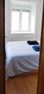 a bedroom with a white bed with two windows at EZY Ramos apartment Alfama in Lisbon
