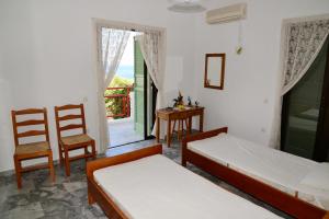 a bedroom with two beds and a table and chairs at Tiros Apartments Armonia in Tyros