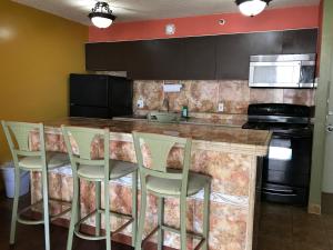 a kitchen with a counter with chairs around it at Waikiki Banyan in Honolulu