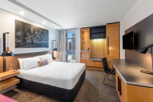a hotel room with a bed and a tv at Mercure Brisbane King George Square in Brisbane