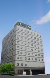 a large building with a clock on the front of it at Hotel Route-Inn Aomori Ekimae in Aomori