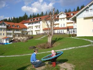 a boy and a child playing in alatablelatable boat at Komforthotel Ahornhof in Lindberg