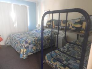 a bedroom with two bunk beds and a bed at Kalbarri Backpackers YHA in Kalbarri