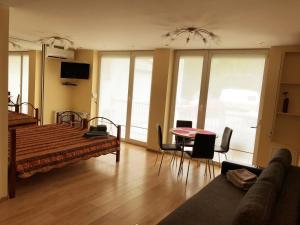 Apartment في سفينتوجي: غرفة معيشة مع سرير وطاولة وكراسي