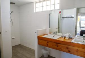 
a bathroom with a toilet, sink, and mirror at Maand Up in Fremantle
