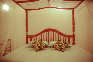 una cama con dosel y 2 almohadas. en Anjana Villa, en Galle