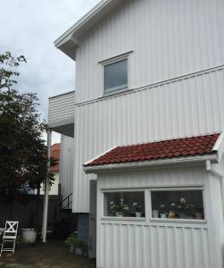 呂瑟希爾的住宿－Accommodation for 2 in the center city of Lysekil，白色的房子,有窗户和红色屋顶