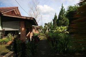 un camino de jardín junto a una casa de ladrillo en Princess Cottages en Sukabumi