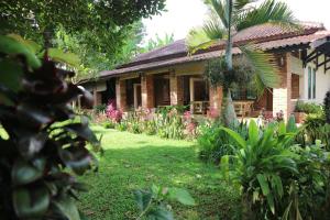 a house with a garden in front of it at Princess Cottages in Sukabumi
