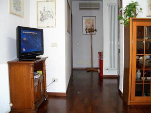 ein Wohnzimmer mit einem TV auf einem Holzständer in der Unterkunft Mamma Mia on ground floor with private parking TV-VENICE in Treviso