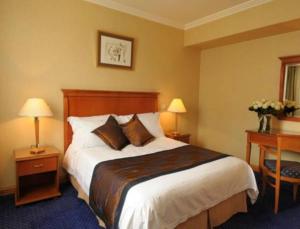 a hotel room with a large bed and two lamps at Castelli Hotel Nicosia in Nicosia +88 photos