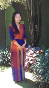 a woman in a colorful dress standing next to a tree at Glory Homestay in Kandy