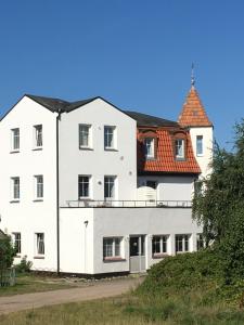 a white building with a red roof at Pension "Strandhotel" in Vitte