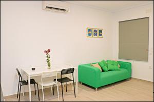 コニル・デ・ラ・フロンテーラにあるApartamento rural en Conilのリビングルーム(緑のソファ、テーブル付)
