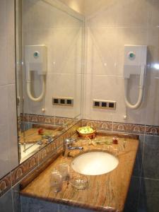 a bathroom with a sink and a shower with a mirror at Motel Trebol in Tui
