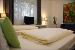 una camera d'albergo con due letti e una televisione di Hotel Gasthof Alte Post - Restaurant offen a Oberding