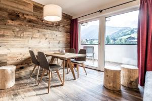 a dining room with a wooden wall and a table and chairs at die Schneiderei in Kaprun