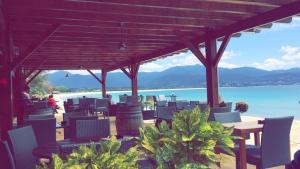 a patio with chairs and tables and a view of the ocean at Studio Rue Fesch - Vieille Ville in Ajaccio