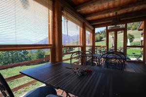 a dining room with a table and chairs on a porch at Lou Subric in Stroppo