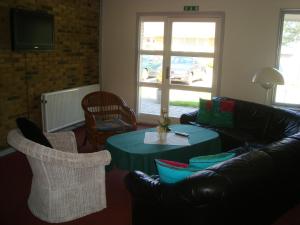 a living room with a couch and a table and chairs at Hotel Falken in Videbæk