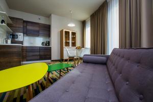 a living room with a couch and a table and a kitchen at Baltic Park Molo Apartments by Zdrojowa in Świnoujście