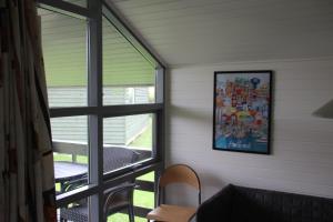 een kamer met een raam en een tafel en stoelen bij First Camp Holbæk Fjord in Holbæk