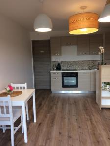 a kitchen with a white table and a table and chairs at Au charmant des vignes in Montagne