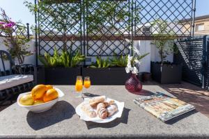 una mesa con un tazón de pan y un tazón de naranjas en City Rooftop Paradise - Space Maison Apartments, en Sevilla