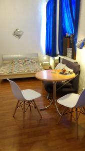 キーウにあるApartment on Horodetskoho 4のベッド、テーブル、椅子が備わる客室です。