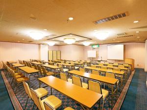 an empty lecture room with tables and chairs at Hotel Pearl City Sendai in Sendai