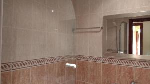 uma casa de banho com um chuveiro, um espelho e um lavatório. em Cómodo Apt 40m playa . em Noja