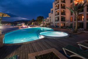 una piscina por la noche en un hotel en Marina City ApartHotel en Balchik