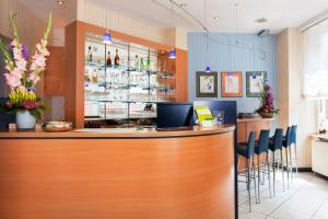 a bar in a restaurant with a counter and stools at Hotel Plaza in Frankfurt/Main