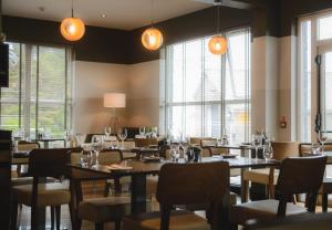 a dining room with tables and chairs and windows at Kirklea Island Suites in Tarbert