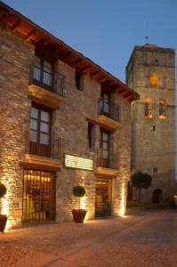 a large stone building with a large tower at Apartamentos El Palacete de Ainsa in Aínsa
