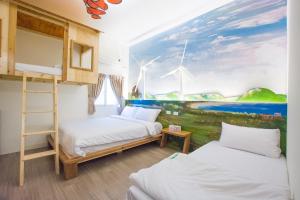 2 letti in una camera con un dipinto sul muro di 解憂海灣Chill Bay潛水旅店 a Città Vecchia di Hengchun