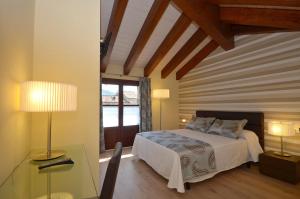 a bedroom with a bed and a table with a lamp at Apartamentos El Palacete de Ainsa in Aínsa