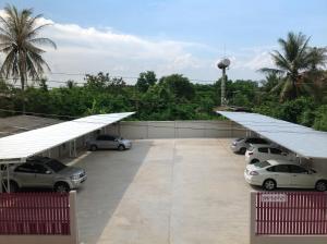 a parking lot with parked cars and white roofs at Siri Sothorn Apartment in Chachoengsao