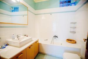 a bathroom with a sink and a tub and a toilet at Loft near the beach in Loutraki +9 photos