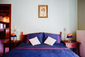路特奇的住宿－Loft near the beach，一张蓝色的床,配有两张桌子和两盏灯