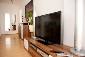 a flat screen tv sitting on top of a wooden entertainment center at Apartments City Room Berlin in Berlin