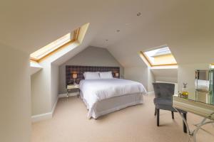a bedroom with a bed and a desk and windows at Garleton Lodge in Haddington