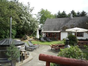 un patio trasero con una mesa y sillas y una casa en Lille Degnbøl Holiday House, en Degnbøl