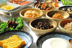 a table topped with bowls of different types of food at Daiwa Roynet Hotel Tokyo Akabane in Tokyo
