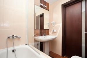 a bathroom with a tub and a sink and a shower at Easy Room in Nizhny Novgorod