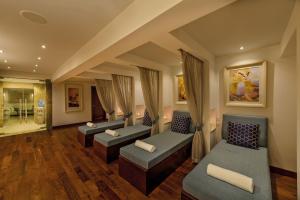 a waiting room with couches and chairs in a building at Grand Hotel Gozo in Għajnsielem